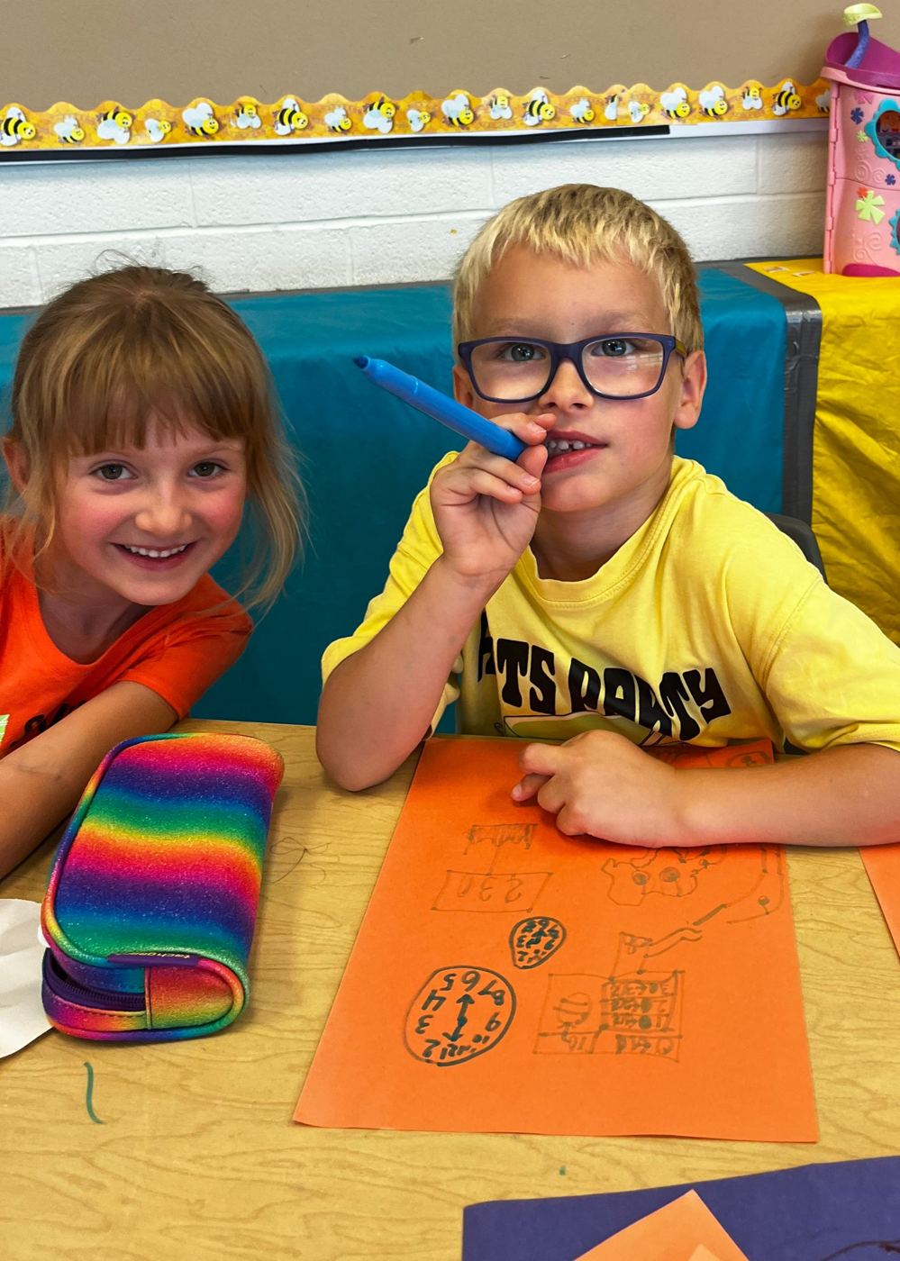Two smiling campers drawing together